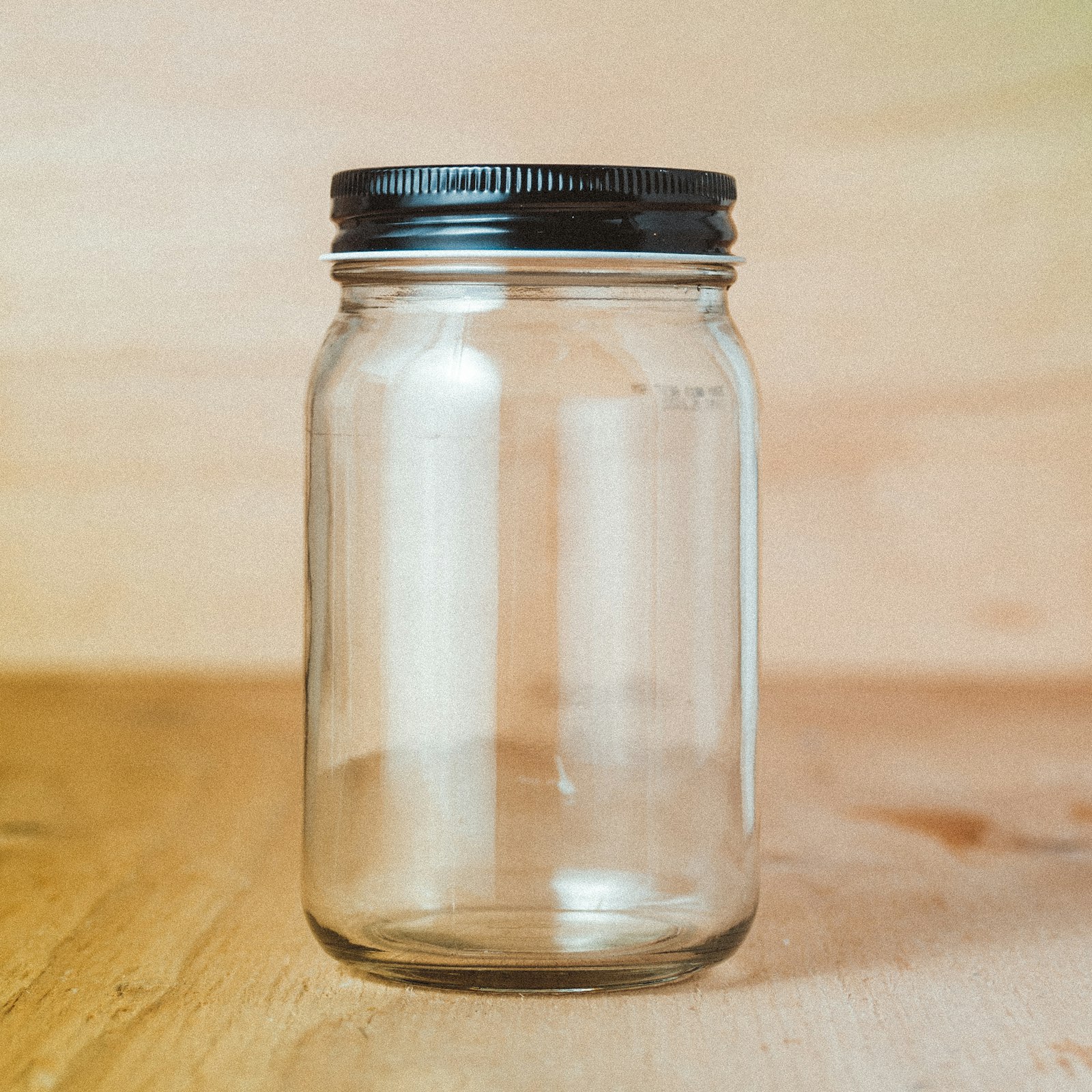 An empty glass jar on a kitchen counter, ready to be filled with coins for savings