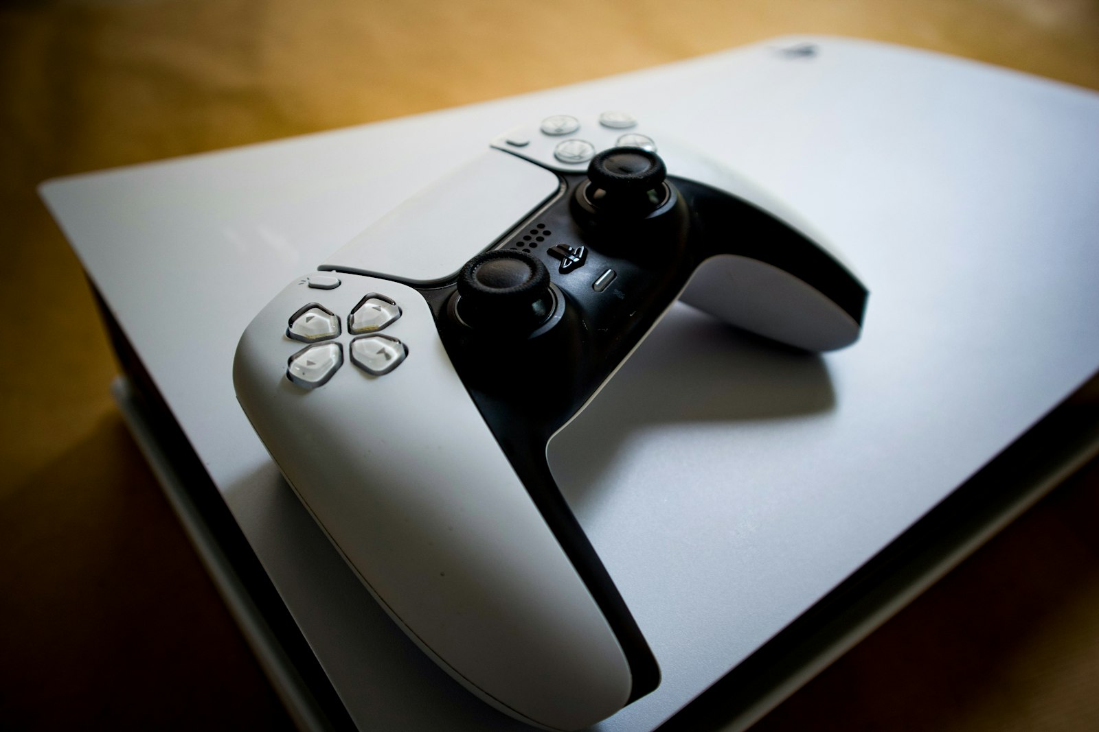 A PlayStation 5 console with its DualSense controller resting on top